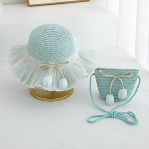 Detail of light blue straw sun hat and matching bag with tulip ribbon decorations