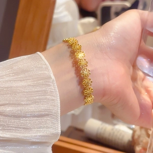 Close-up of elegant gold cutout daisy flower bracelet on a female wrist detail