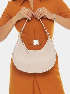Detailed macro of pebble leather texture and silver buckle on the beige hobo bag