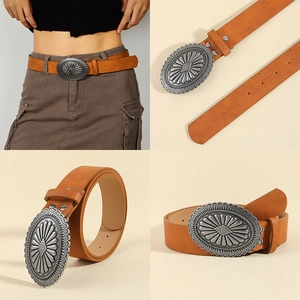 Detail of vintage brown leather belt with large engraved silver oval buckle for jeans