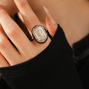 Close-up of vintage gold-plated ring with abalone shell stone and crystal border