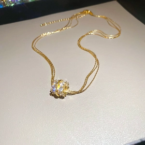 Detail of gold-plated multi-layer cylinder pendant with sparkling zircon stones