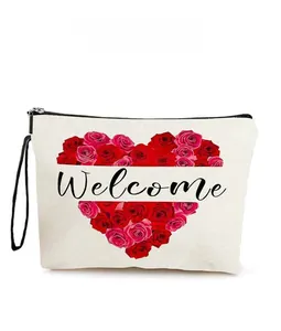 Détail de la trousse de maquillage en toile crème avec motif de roses en cœur et dragonne