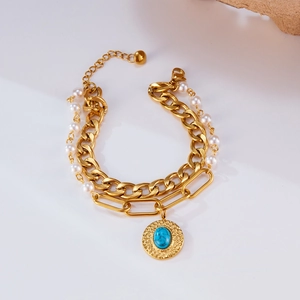 Detail of multi-layer gold bracelet with pearls, curb chain, and turquoise stone pendant