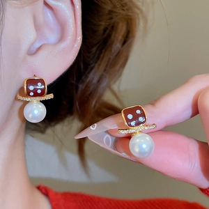 Macro shot of 18K gold plated earring with red dice charm and 10mm white pearl