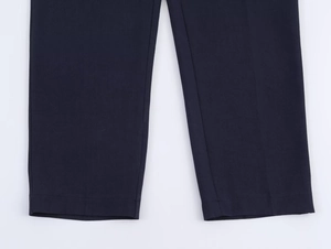 Detail view of navy blue trousers showing the flat-stitched hem and high-density fabric