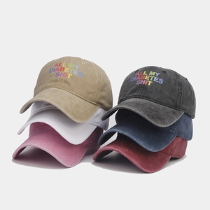 Detail of multi-colored washed cotton baseball caps with rainbow letter embroidery