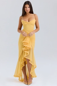 Detail of yellow ruched dress with thin spaghetti straps and layered ruffle hemline