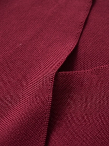 Macro shot of burgundy knit fabric texture and overlap V-neckline detail for sweater
