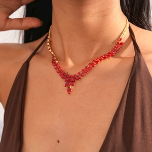 Gros plan du collier à pendentif épi de blé avec zircons rouges sur le cou d'un mannequin