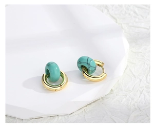 Macro view of vintage gold hoop earrings featuring turquoise stone bead accents