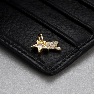 Macro shot of gold star pendant with sparkling gemstones on premium leather surface
