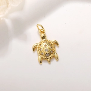 Macrodetail van een gouden schildpadhanger met zirkoon en gegraveerde patronen