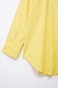 Detailed view of yellow and white striped shirt featuring button cuffs and hemline stitching