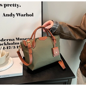 Detailed shot of olive nylon tote with brown leather handles and adjustable shoulder strap