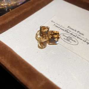 Macro shot of gold-plated ear cuff with champagne crystals in round and square cuts