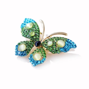 Detailed view of butterfly brooch with gradient green rhinestones and opal-like stones
