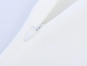 Close-up of a white invisible zipper with raindrop slider on woven fabric of women's set