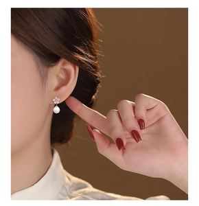 Close-up of pink cherry blossom earrings with round white pearls on 999 silver