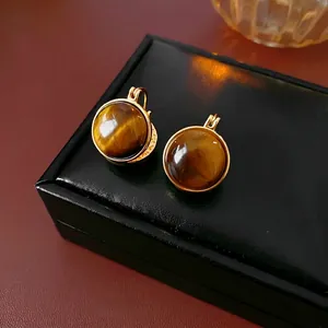 Boucles d'oreilles vintage dorées avec pierres œil de tigre sur cuir noir élégant