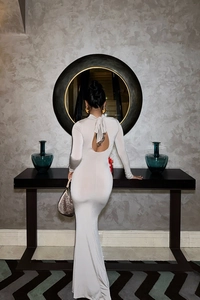 Détail d'une élégante robe midi dos nu de couleur crème avec nœud au cou pour femmes