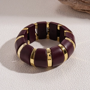 Detail of wide stretch bracelet featuring burgundy resin blocks and gold metal spacers