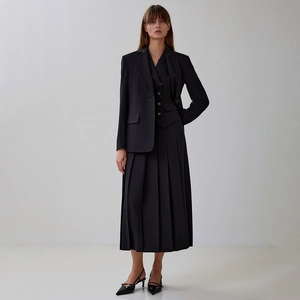 Détail de l'ensemble trois pièces noir pour femme avec gilet, veste et jupe plissée