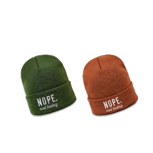 Dunkelgrüne und karamellfarbene Strickmützen mit weißer NOPE-Stickerei für Damen und Herren