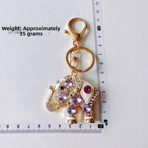Detailed view of elephant keychain with purple rhinestones and size measurement ruler