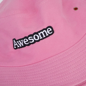 Détail de la texture en coton rose et de la broderie Awesome sur le chapeau soleil