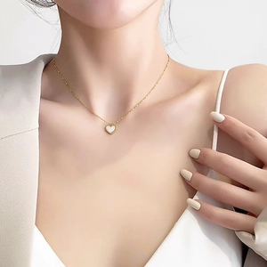 Elegant gold stainless steel heart necklace with white shell pendant on female model