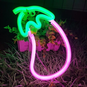 Vibrant eggplant LED neon light illuminating a garden setting with pink and green glow