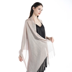 Detail of elegant light gold shawl with shimmering silver thread and fringe tassels