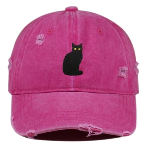 Macro detail of distressed hot pink cotton baseball cap with black cat embroidery