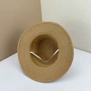 Detailed close-up of woven straw sun hat showing natural texture and elastic wind rope