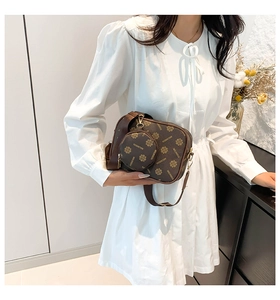Deep brown monogram camera bag with small round coin purse shown in life-style setting