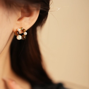 Detailed view of round gold beads and white pearls alternating on a French vintage earring