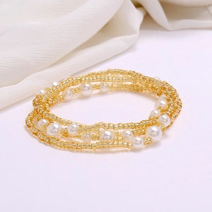 Detail of layered waist chain featuring gold seed beads and white imitation pearls