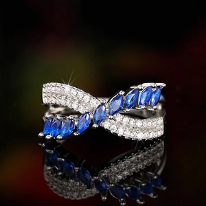 Detail of cross wrap ring with blue marquise gems and white pavé stones on silver band