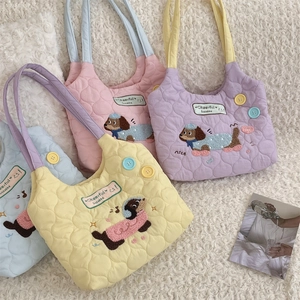 Detail of colorful quilted tote bags with puppy embroidery and pastel macaron tones