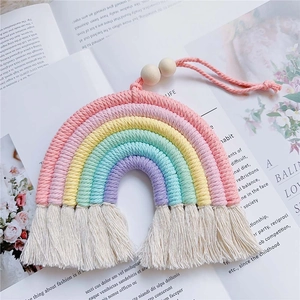 Detail of handmade cotton rope rainbow wall hanging with natural wooden beads and tassels