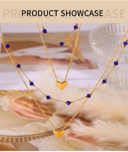 Detailed close-up of a three-layer gold heart necklace with elegant blue beads and feathers