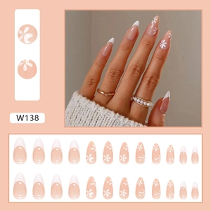 Press-on nail set featuring white French tips and daisy designs on nude long almond nails