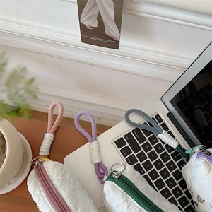 Detailed close-up of quilted storage pouches with colorful ropes on a minimalist desk