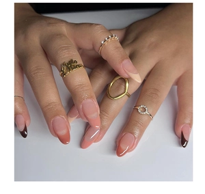 Detail of almond-shaped peach and pink gradient press-on nails with French design