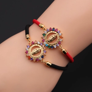 Detail of hand wearing Virgin of Guadalupe woven bracelets with colorful zirconia stones