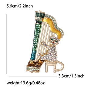 Detailed view of harp cat brooch with size measurements 5.6cm by 3.3cm on white background