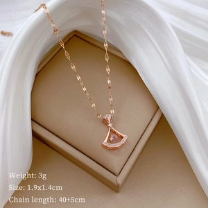 Macro shot of rose gold fan pendant with crystals on silk, showing 1.9x1.4cm dimensions
