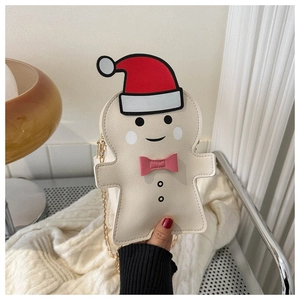 Macro shot of gingerbread man chain bag with a festive hat and golden metal strap
