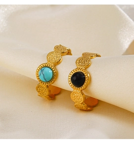 Detail of vintage gold plated rings with turquoise and black onyx on silk display